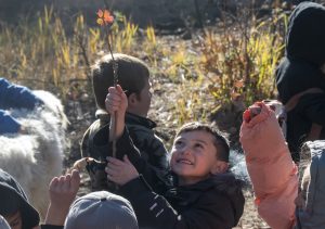 Friday Outdoor School in Mora, NM. A boy holds up a flower.