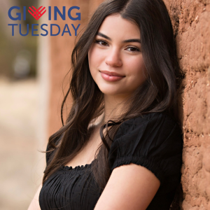 Elena Gallegos leaning against an adobe wall, smiling. With Giving Tuesday logo.